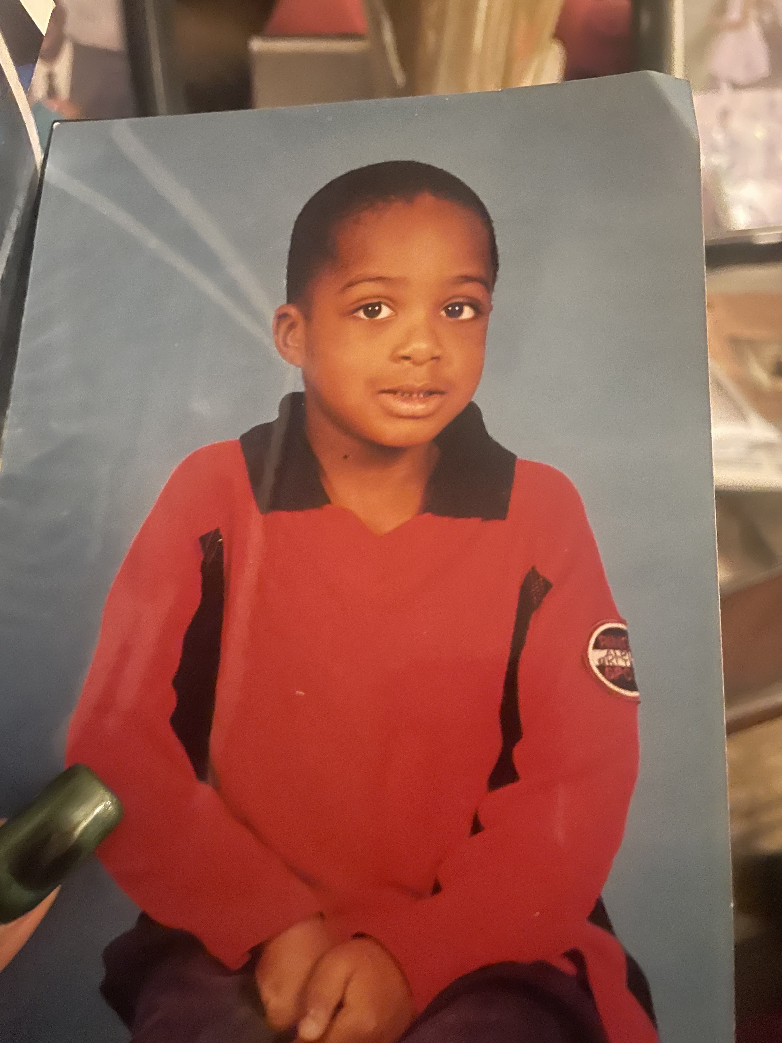 Foto de referencia de OpenAI: un niño con camisa roja en un retrato de estudio impreso